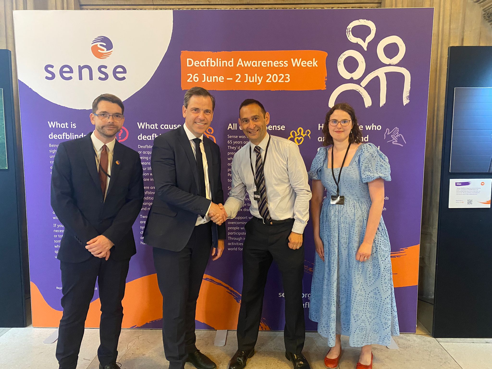 Chris Evans MP stands with three representatives from Sense. Background board reads Deafblind Awareness Week 26th June to 2nd July